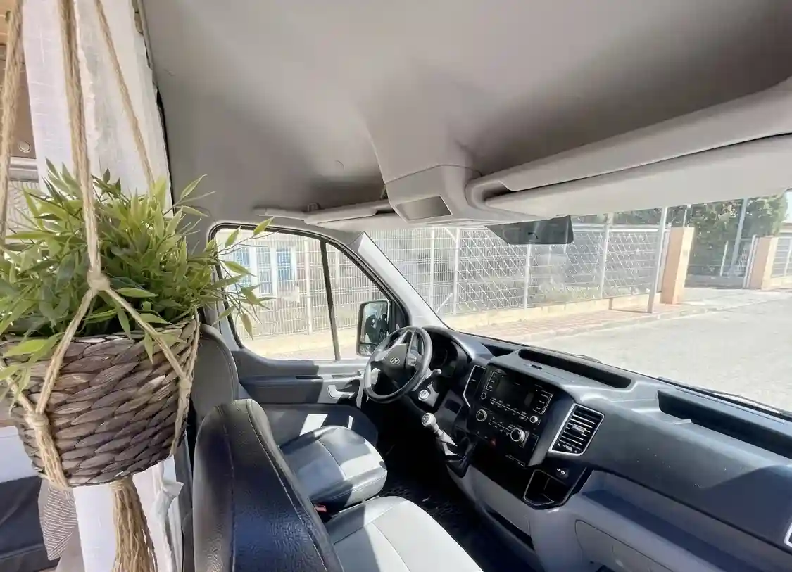 Puesto de conducción y cabina de la furgoneta camper Hyundai H350 en alquiler en Ibiza.