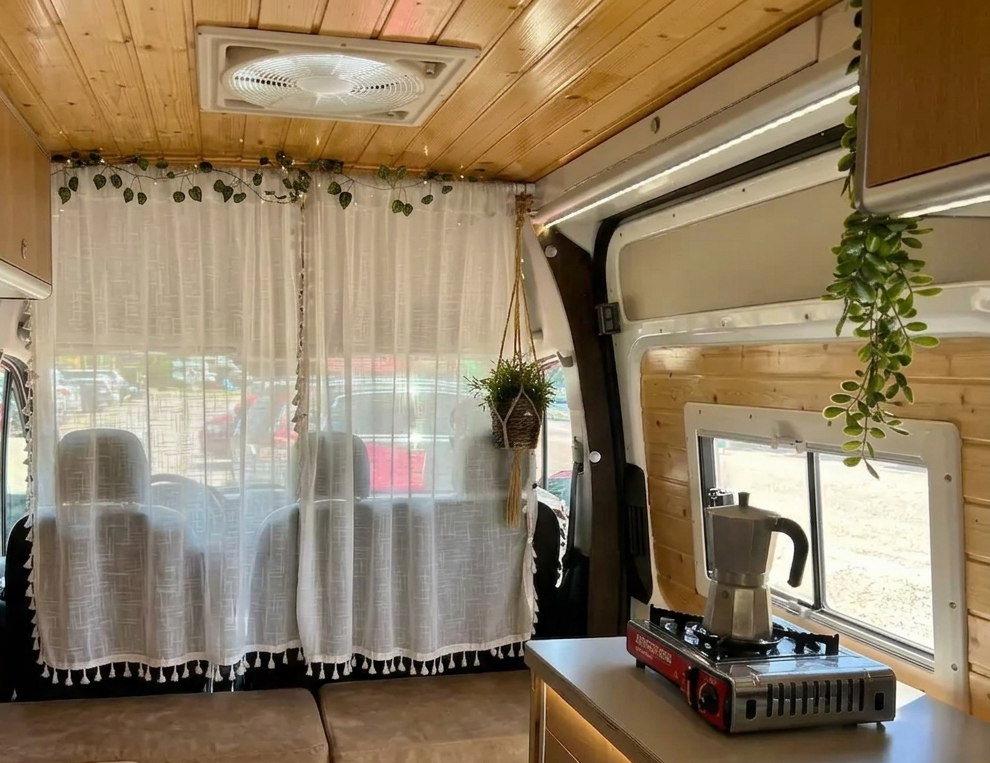 Vista desde la puerta lateral de la camper Hyundai H350 hacia la cabina de conducción.